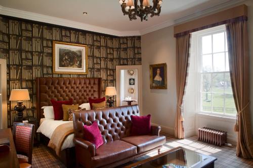 奥尔德梅尔德拉姆米氏家高尔夫乡村酒店的一间卧室配有一张床和一张沙发