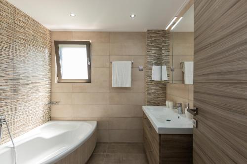 加藤-达拉特索Peris Villa的带浴缸和盥洗盆的浴室