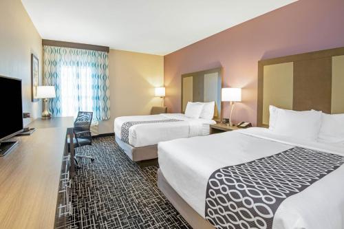 韦瑟福德La Quinta by Wyndham Weatherford OK的酒店客房设有两张床和一台平面电视。