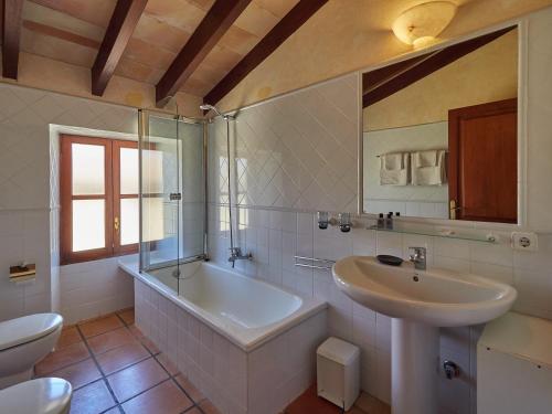 锡内乌Sa Barcella的带浴缸、盥洗盆和卫生间的浴室