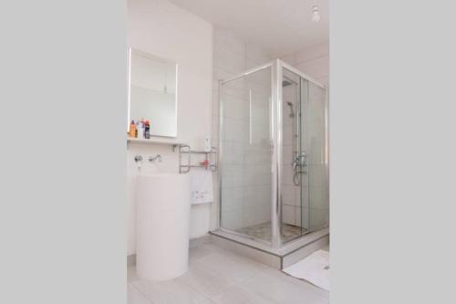 马埃堡Maison des Paquerette的浴室设有玻璃淋浴间,拥有白色的墙壁