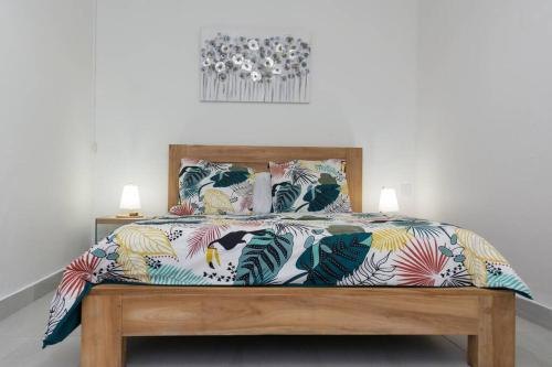 马埃堡Maison des Paquerette的一张带五颜六色的被子和两盏灯的床