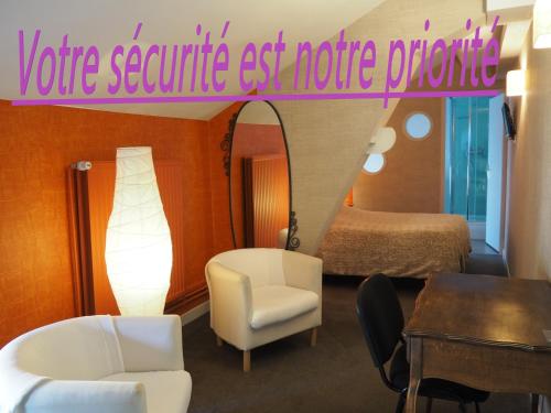 图勒Hôtel La Villa Lorraine的酒店客房配有床、桌子和镜子