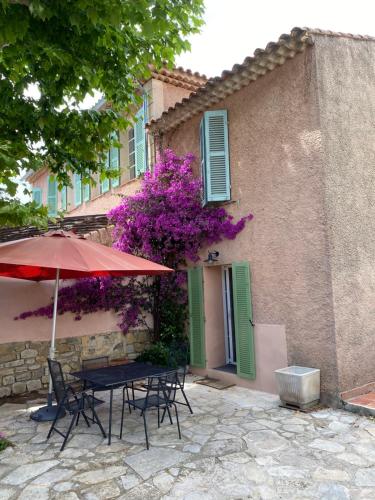 土伦Petite maison au calme avec jardin clim et parking的大楼前的桌椅和遮阳伞