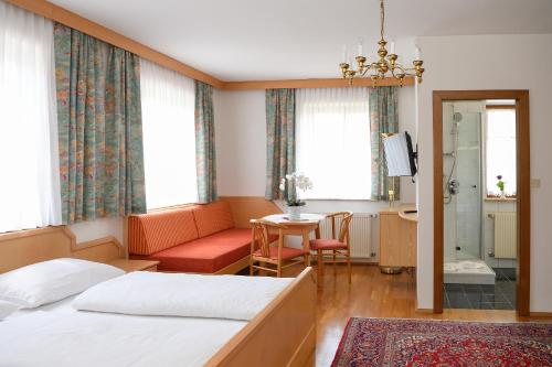 SchwanbergSchwanbergerstüberl的一间卧室配有一张床、一张沙发和一张桌子