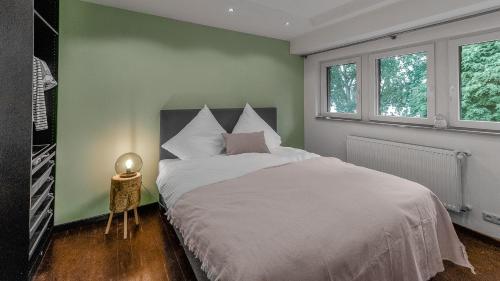 科隆Das Wiesenhaus: Wohnen direkt am Rhein的卧室配有白色的床和绿色的墙壁