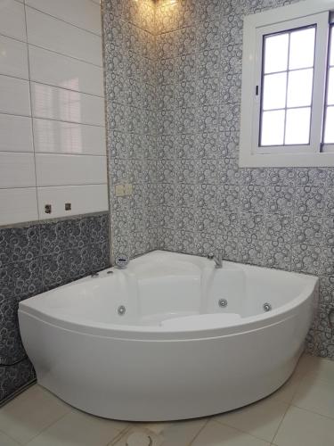 欧奈宰منتجع القصر الأبيض的带窗户的浴室内的白色浴缸