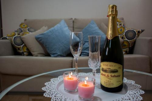 麦地那西多尼亚Apartamento Torreon的一瓶香槟和一张桌子上的两根蜡烛
