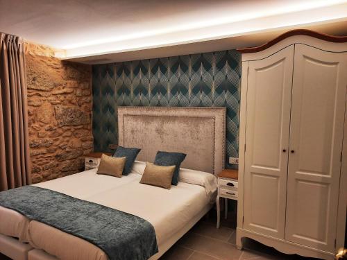 穆希亚Solpor do Coído的一间卧室设有一张特大号床和石墙