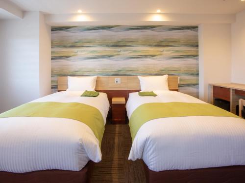 FukuroiKuretake Inn Premium Fukuroi Ekimae的墙上画画的房间里设有两张床
