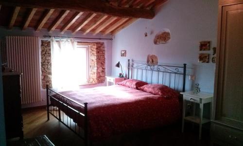 马萨罗萨La Coccinella di Silvia e Simone的一间卧室配有一张带红色毯子的床和窗户。