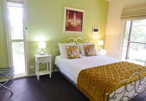 蒙特维尔Apple Tree Cottage Montville的一间卧室设有一张黄色墙壁和窗户的床