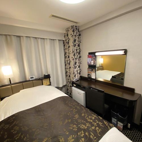 丰桥市APA Hotel Toyohashi-Ekimae的酒店客房,配有床和镜子