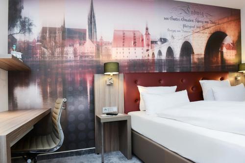 雷根斯堡ACHAT Hotel Regensburg im Park的酒店客房配有一张床、一张书桌和一张书桌。