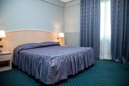 奇维塔卡斯泰拉纳艾尔德罗酒店的一间卧室配有一张带蓝色毯子的床