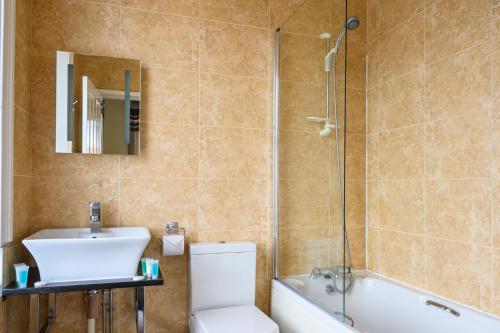 惠特比The White House Inn - Whitby的浴室配有卫生间、盥洗盆和淋浴。