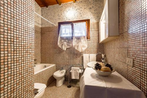 斯卡尔利诺Tortuga Casa Vacanze的浴室配有盥洗盆、卫生间和浴缸。