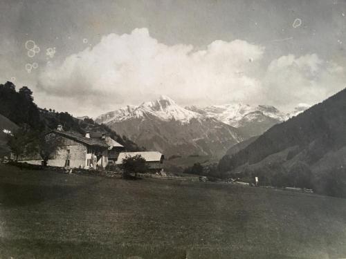 莱热Résidence La Chaumière的一张黑白相间的旧房子和山峰照片