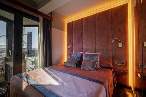 塞维利亚ON Suites Sevilla Apartments designed for adults的一间卧室设有一张大床和大窗户