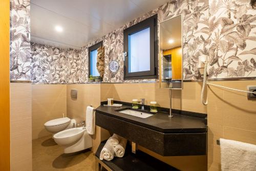 塞维利亚ON Suites Sevilla Apartments designed for adults的一间带水槽、卫生间和镜子的浴室