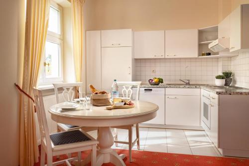 巴特格里斯巴赫Klosterhof St. Salvator的一间白色的厨房,配有桌椅
