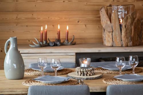 拉赫兹耶尔Residence Miravidi La Rosiere的一张桌子,上面放着蜡烛和盘子,还有酒杯