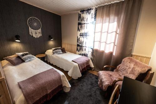 KiviperäIsokenkäisten Klubi - Wilderness Lodge的酒店客房设有两张床和窗户。