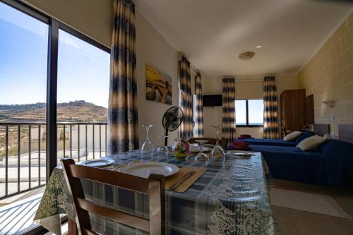 马萨尔福恩落日海景公寓式酒店的客厅设有一张桌子,享有美景。