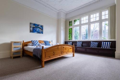 利物浦No 1 - LARGE 1 BED NEAR SEFTON PARK AND LARK LANE的一间卧室设有木床和2个窗户。