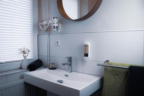 奥滕赫芬Pension Heimat的浴室设有白色水槽和镜子
