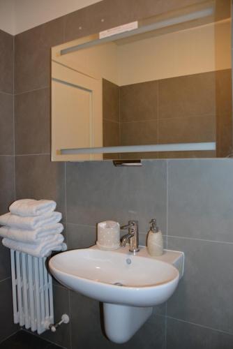 的里雅斯特Appartamento Tergesteo的浴室配有盥洗盆、镜子和毛巾