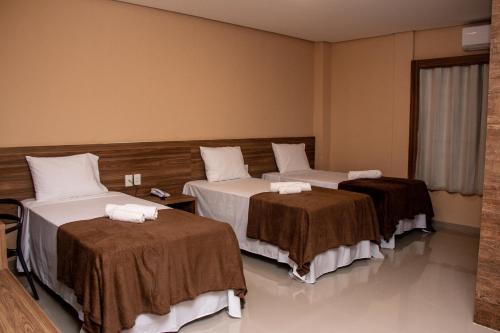 马拉巴INACIO'S PLAZA HOTEL的酒店客房,配有两张带毛巾的床