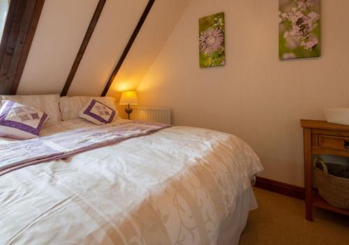 博德明Demelza Cottage Apartment的一间卧室配有一张床和一张带台灯的桌子