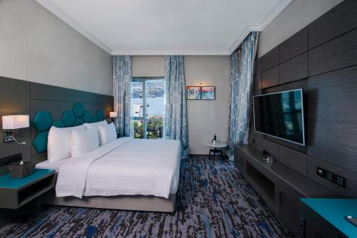 迪拜Edge Creekside Hotel的配有一张床和一台平面电视的酒店客房