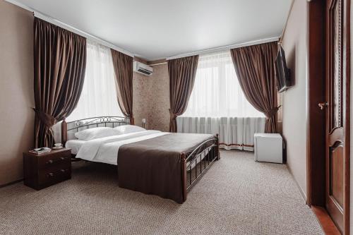 克里扎尼夫卡Bulgary House的一间卧室设有一张床和两个大窗户