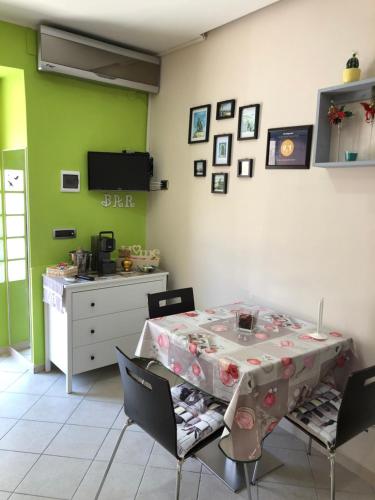 巴列塔Casa vacanza dei Greci的用餐室设有桌椅和绿色墙壁