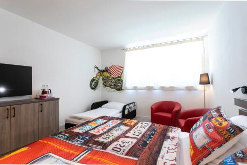 米库洛夫Motel Eldorado的一间卧室配有一张床、一把椅子和电视