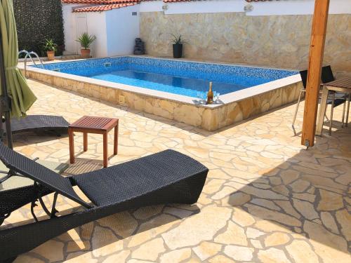 扎达尔Villa Sanda with Private Pool的庭院内的游泳池,配有桌椅