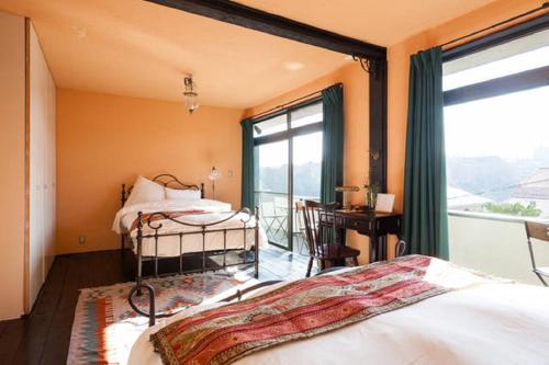 八王子市Villa Takaosan的一间卧室设有一张床和一个美景窗户。