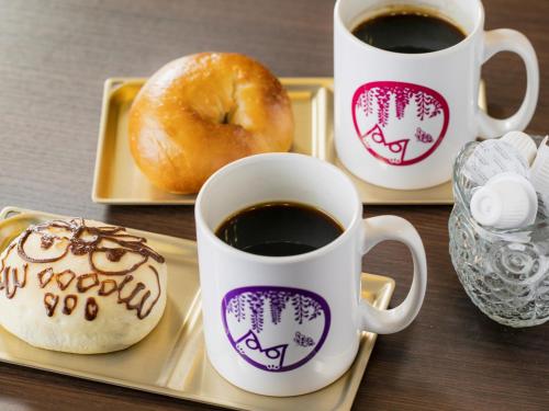 东京Hotel Wing International Select Ikebukuro的盘子里三杯咖啡和甜甜圈