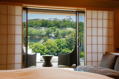 津山市The Shiroyama Terrace Tsuyama Villa的一间卧室设有一张床和一个大型玻璃窗