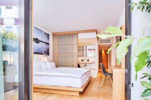巴塞尔ART HOUSE Basel - Member of Design Hotels的配有一张床和一张书桌的酒店客房