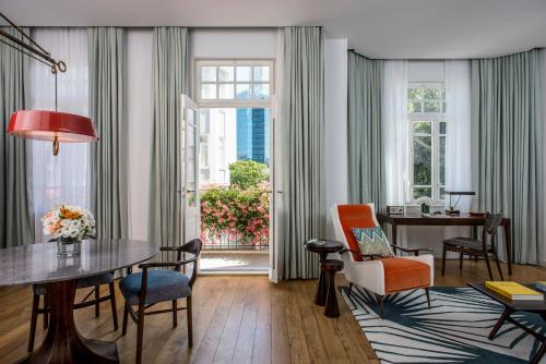 特拉维夫诺曼特拉维夫酒店的客厅配有桌椅和窗户。