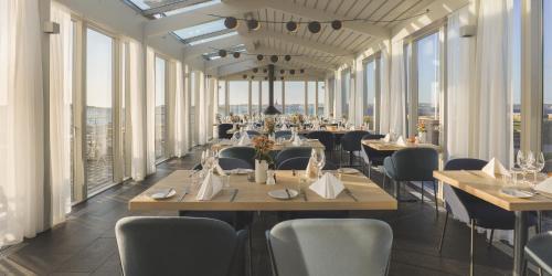 菲斯克拜克希尔加尔马斯斯特兰德酒店与会议中心的用餐室设有桌椅和窗户。