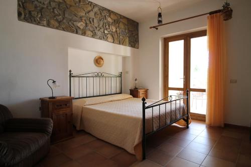 斯坎萨诺MacchiaPiana的一间卧室配有一张床、一张沙发和一个窗口