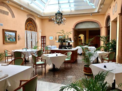 科雷焦Phi Hotel Dei Medaglioni的一间带桌椅和吊灯的餐厅