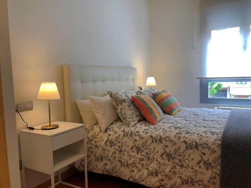 奥维多Apartamento Europa Jardín的一间卧室配有带枕头和台灯的床