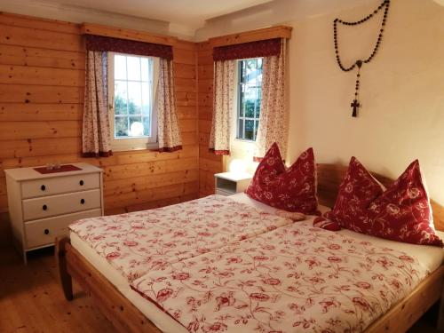 滨湖施图本贝格Hof Zaunfranzl的一间卧室配有红色枕头的床