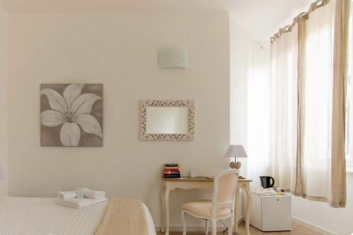 斯培西亚卡萨戴纳酒店的一间卧室配有一张床、一张书桌和一面镜子
