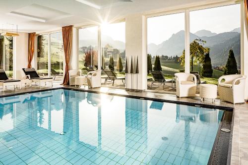 圣维吉利奥Bella Vista Hotel Emma的一个带椅子的游泳池,享有山景